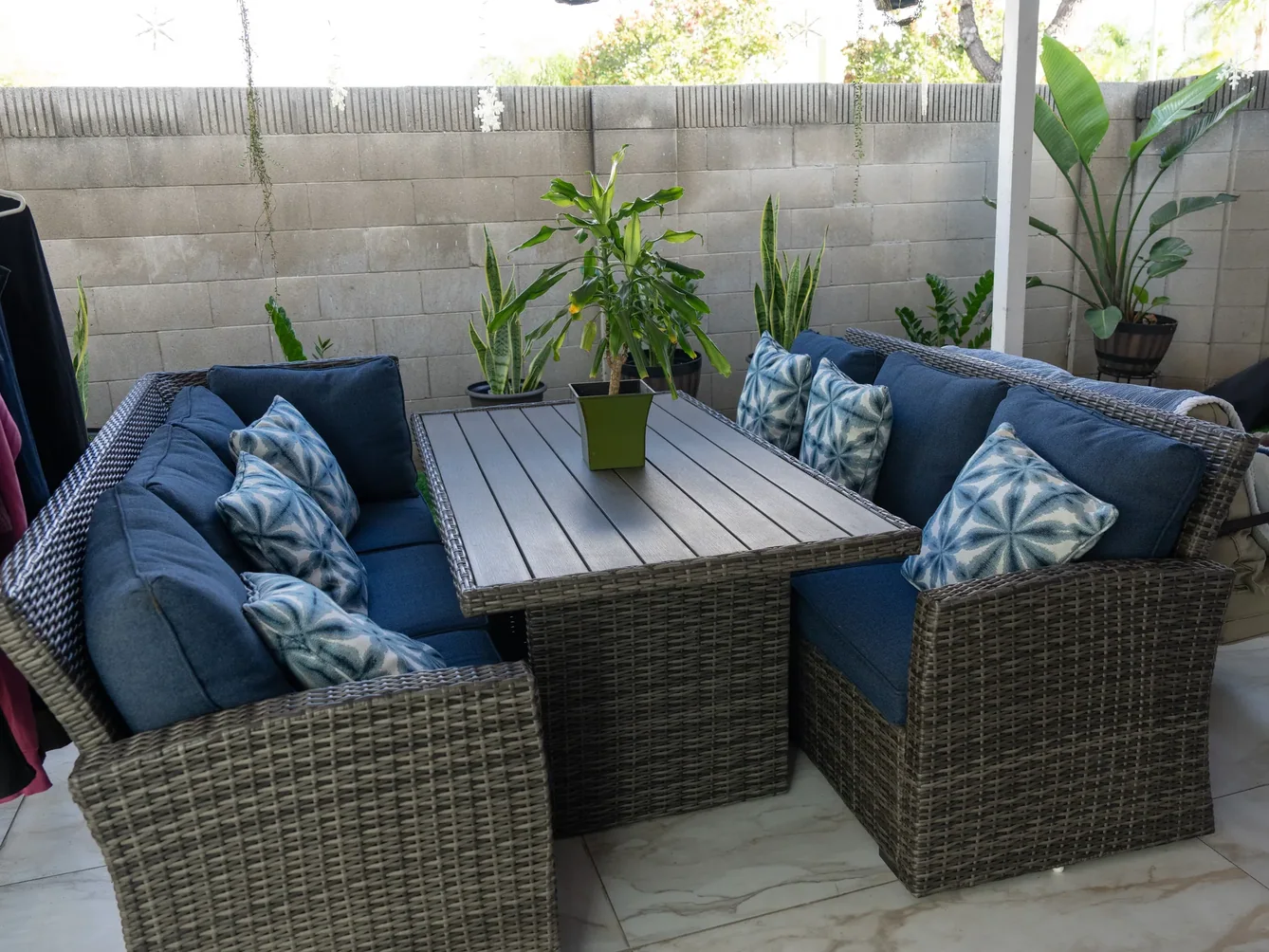 Covered outdoor patio with wicker seating and decorative pillows.