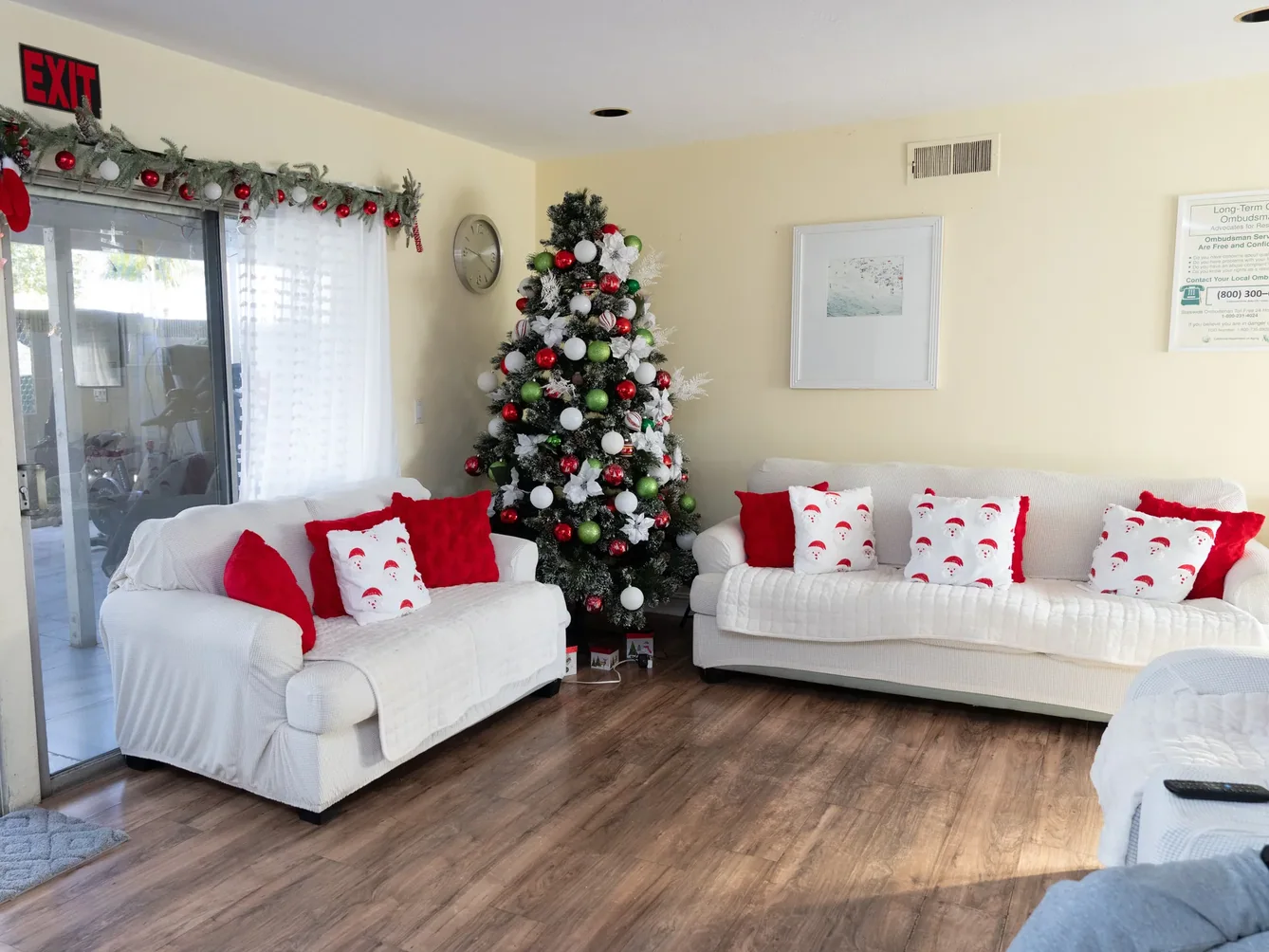 Bright living room with white sofas and festive decorations.