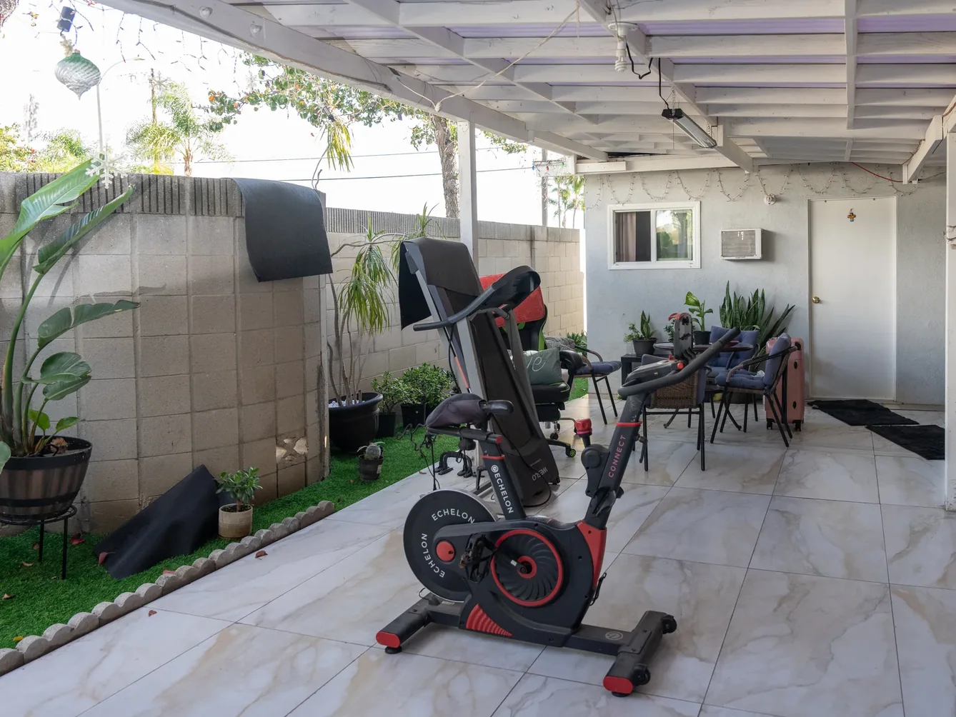 Covered patio rehabilitation area with exercise equipment.