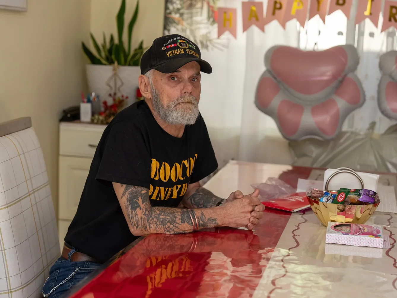 Veteran resident sitting at a table in a comfortable home setting.